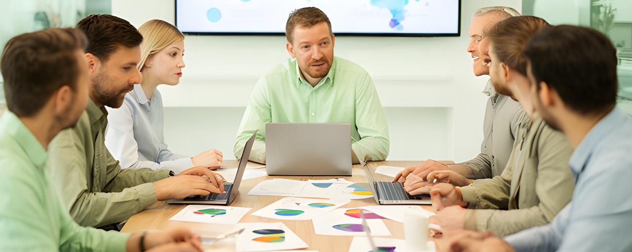Strategy team reviewing supplier risk charts and climate maps around a conference table in a modern office